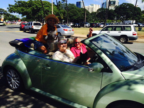 Miss Peggy and Bob Zimmer hold little Rikki and Lucy in a convertible