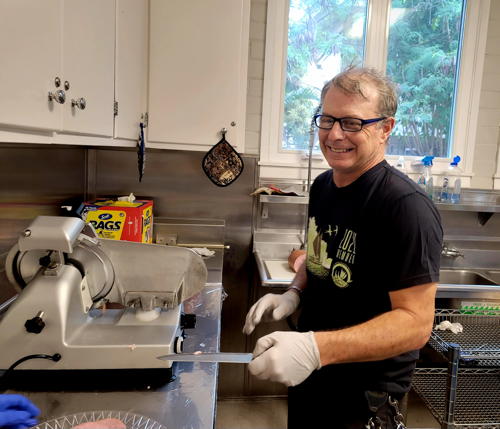 Rich Mundell gets ready to slice meat for IHS sandwiches