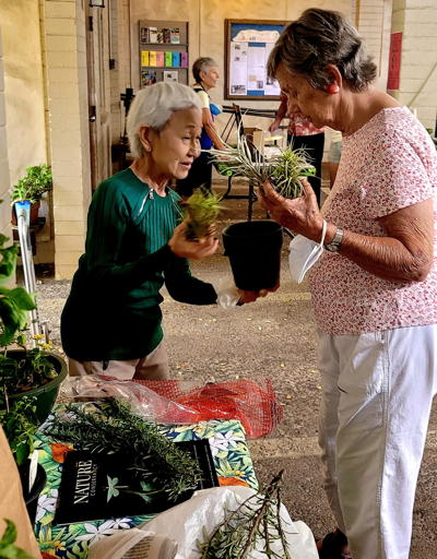 Marlise and Liane are swapping some herbs on Earth Day Sunday.