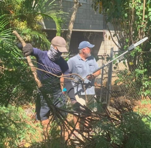 Mike Phoenix and Pr. Jeff cutting back tree branches.