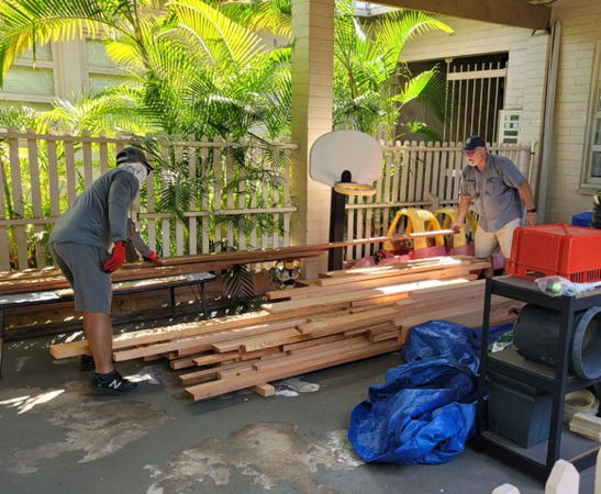 Keane Ishii and Pr. Jeff organizing the wood pile that will go in the storage shed.