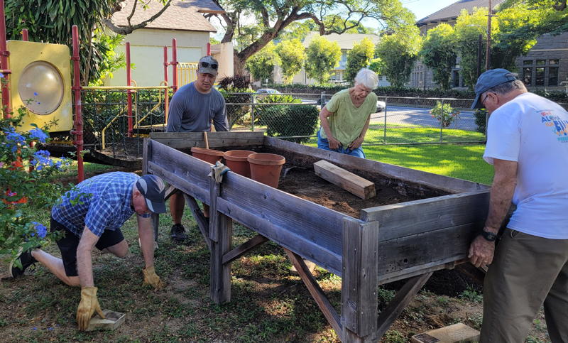 Working really hard to move the heavy planter boxes to the front of the church