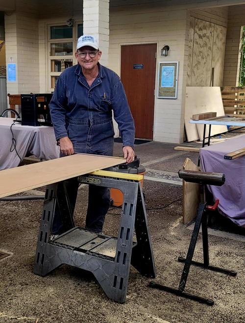 Precision in progress! Eric Lentz carefully measures and cuts wood for the new choir loft, building a strong foundation for beautiful music.