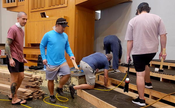 Building harmony through teamwork! Mike Phoenix, Keane Ishii, Steve Hoover, Eric Lentz, and Nolan Endicott join forces to assemble the base of the new choir loft. Strong foundations, stronger team!