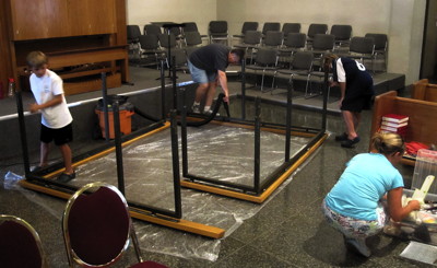 April Smith and members of the Yost family prepare the altar raid for painting.