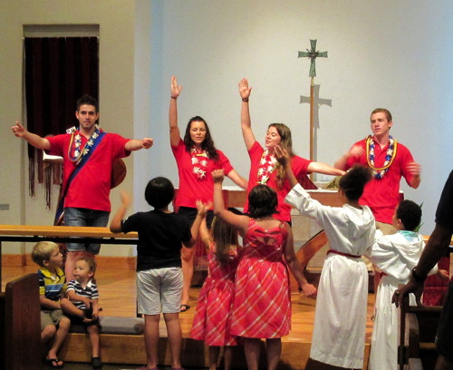 Day camp leaders teaching a song for the children's conversation