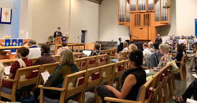 masked worshippers in pews