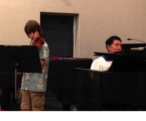 boy playing a violin piece