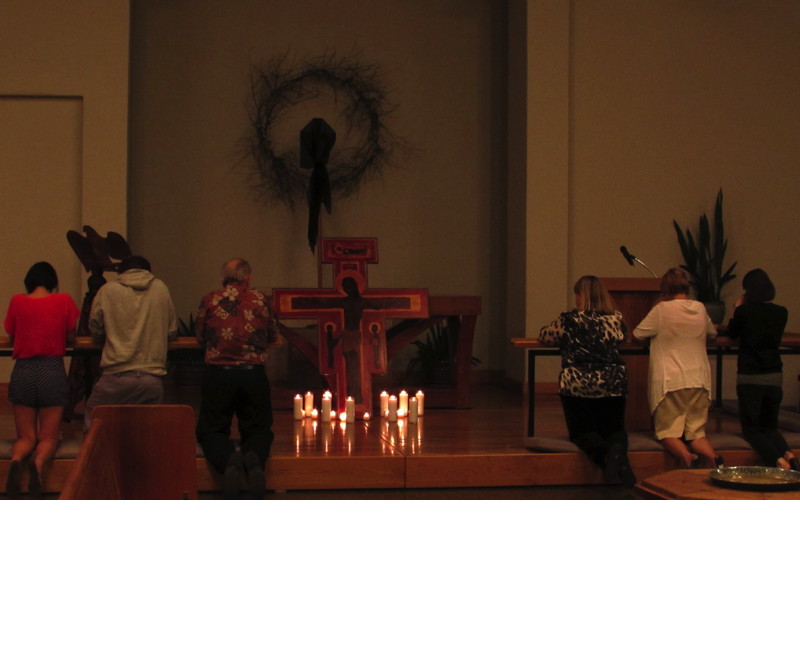 Members of the congregation knelt in prayer before the cross as they left worship.